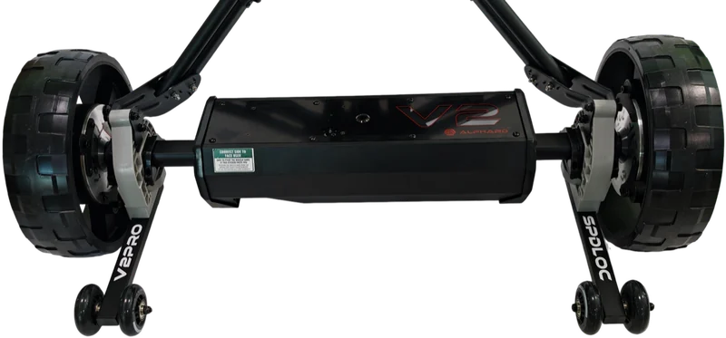 Club Booster V2Pro mounted on a push cart, seen from behind: the wheelie bars printed V2PRO and SPDLOC are pivoted out, the light-gray Speedlock clamps grip the axle bars, and the green CORRECT SIDE TO FACE USER sticker faces you